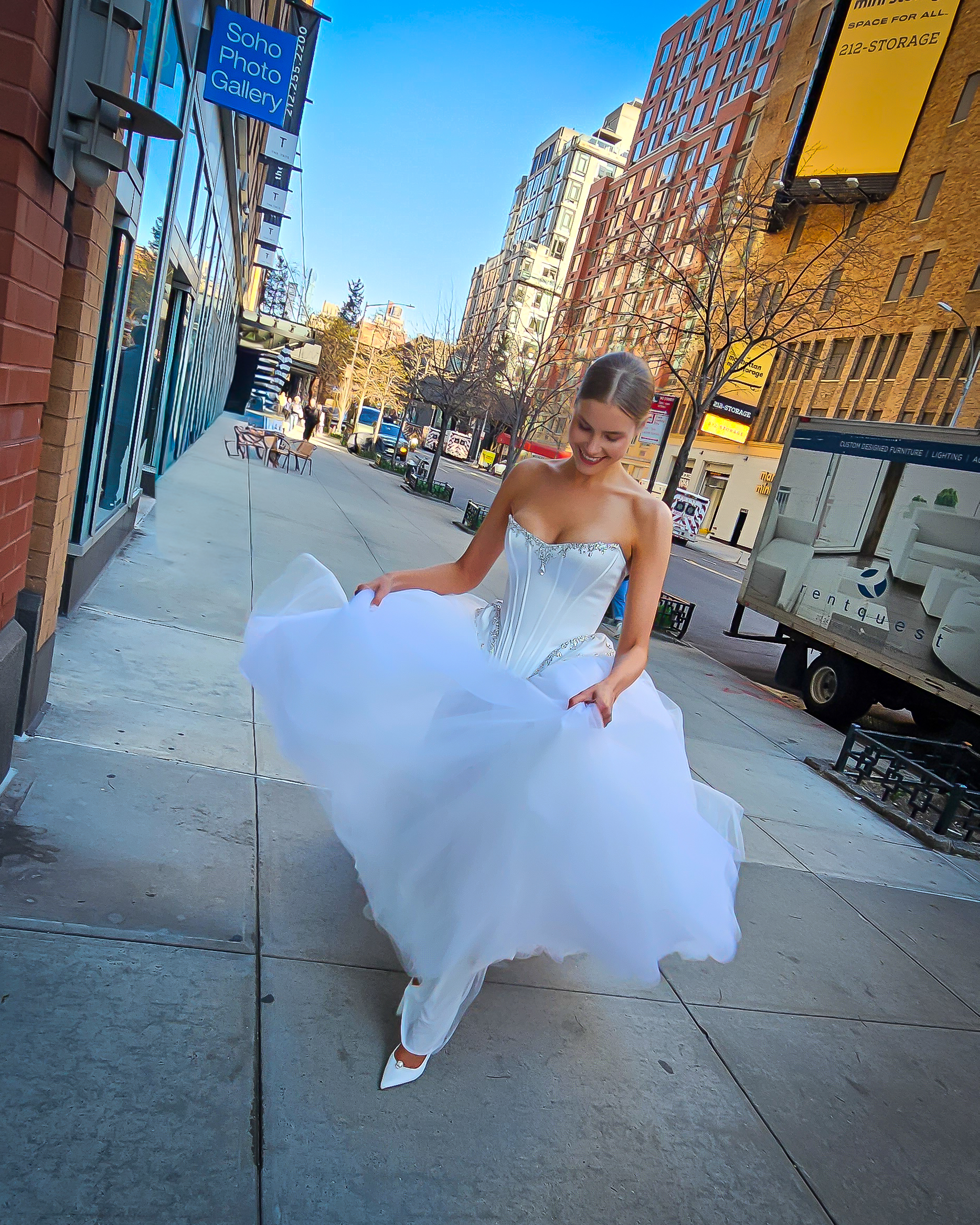 Bride prances down a New York City street during New York Bridal Fashion Week. Pnina Tornai's latest collection will be available at Bridals by Lori during the first week of June 2026. 